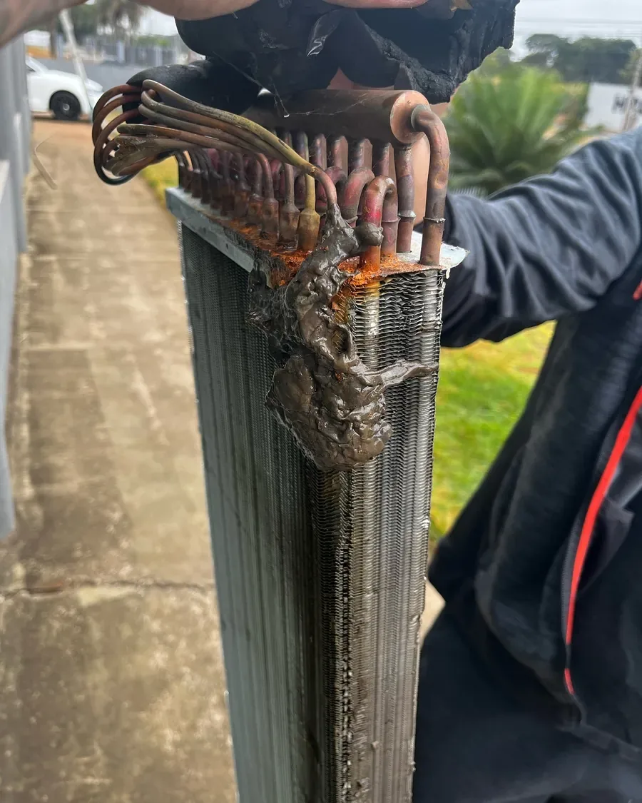 Técnico lavando a serpentina de um ar condicionado desmontado