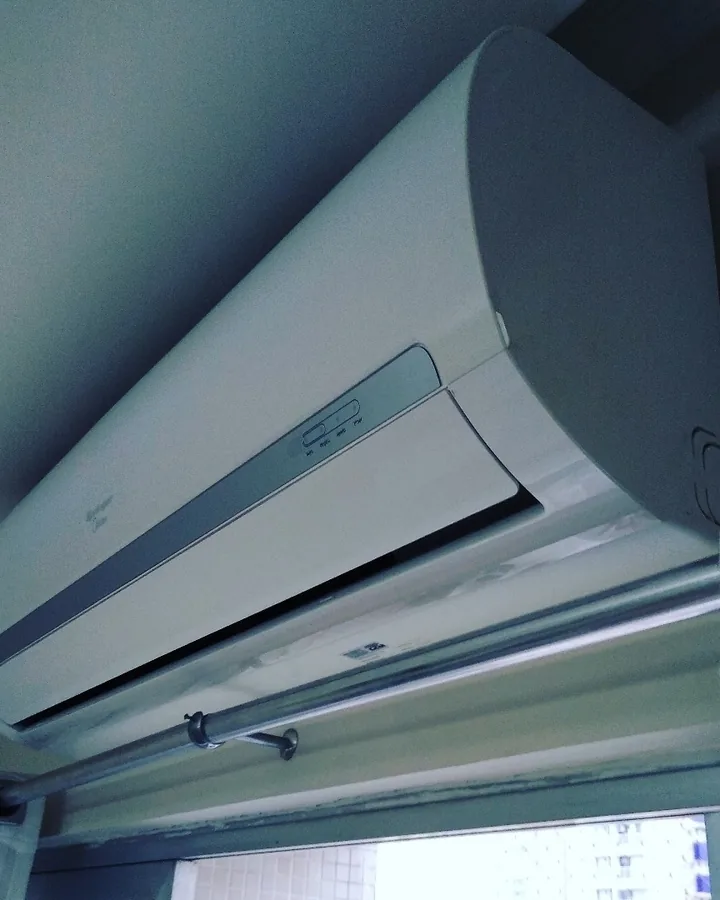 Ar condicionado split branco instalado acima da janela